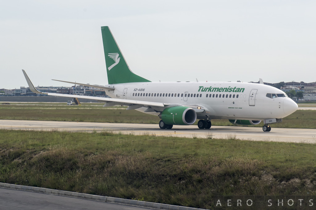 a white and green airplane on a runway