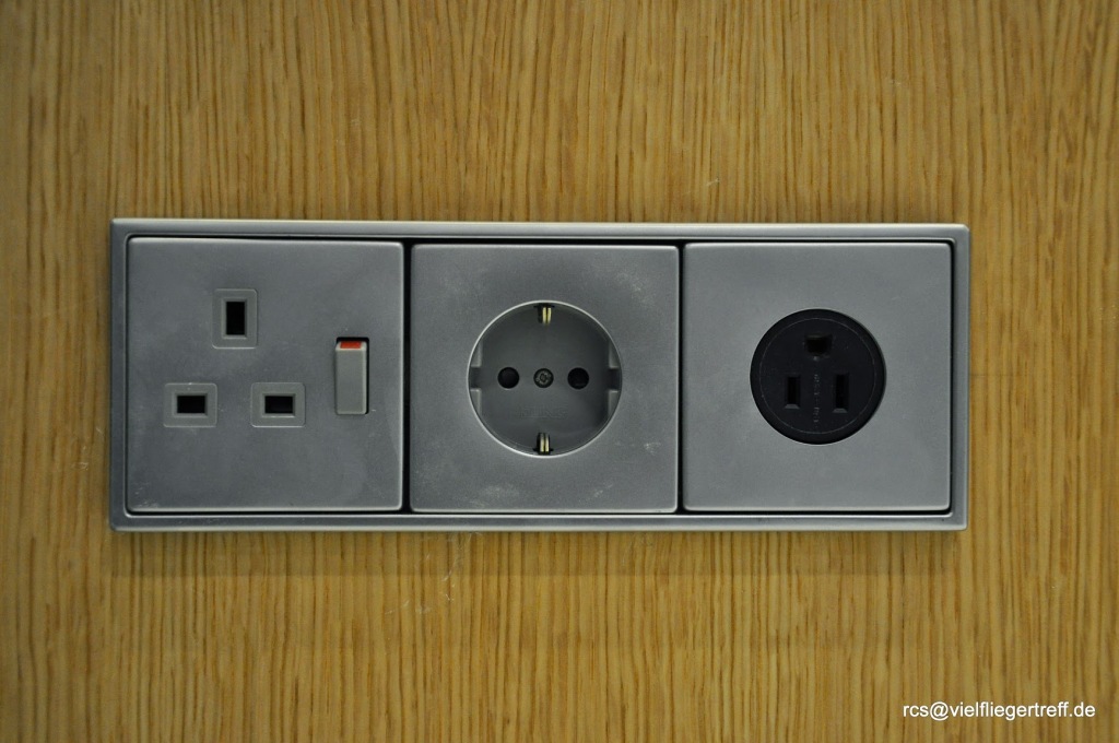 a grey electrical outlet with black and white plugs