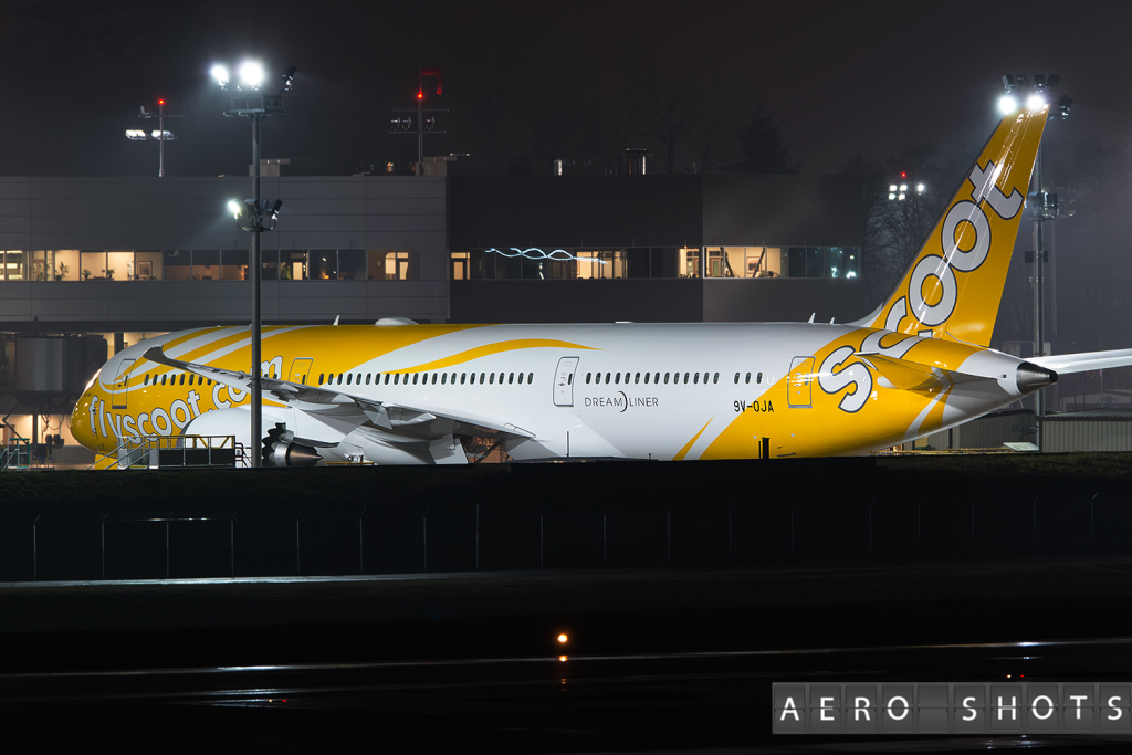 a yellow and white airplane at night