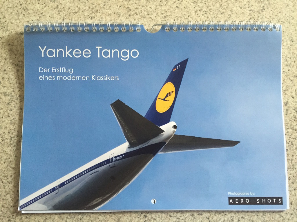 a spiral bound calendar with a picture of a plane