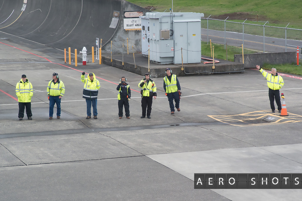 a group of people in safety vests standing on a concrete surface