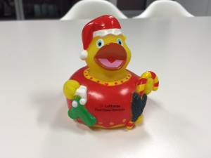 a yellow rubber duck with a red shirt and santa hat