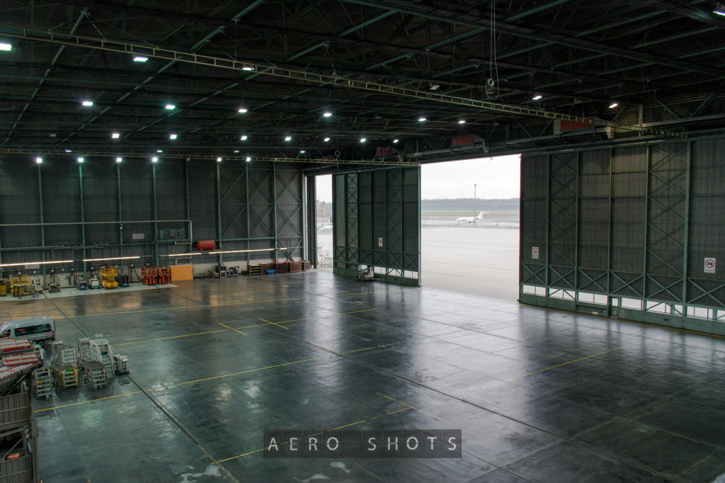 an empty hangar with an airplane in the background