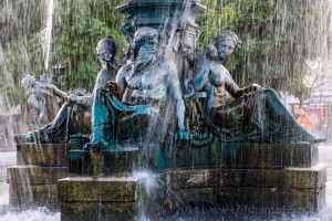 a fountain with statues and water falling