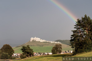a rainbow over a castle on a hill