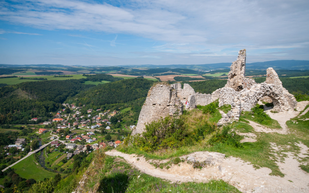 a stone ruins on a hill with a town in the background