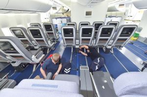 people inside of an airplane with people lying on the floor