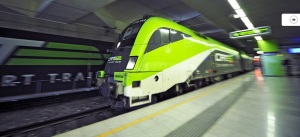 a green and black train in a station