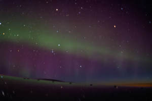 a green and purple sky with stars