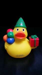 a yellow rubber duck with a hat and a present