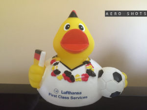 a yellow rubber duck with a football ball and a red beak