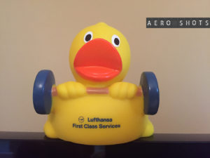 a yellow rubber duck holding weights