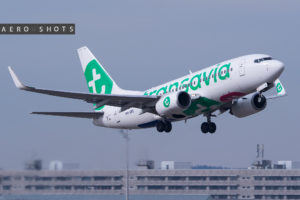 a white and green airplane flying in the sky