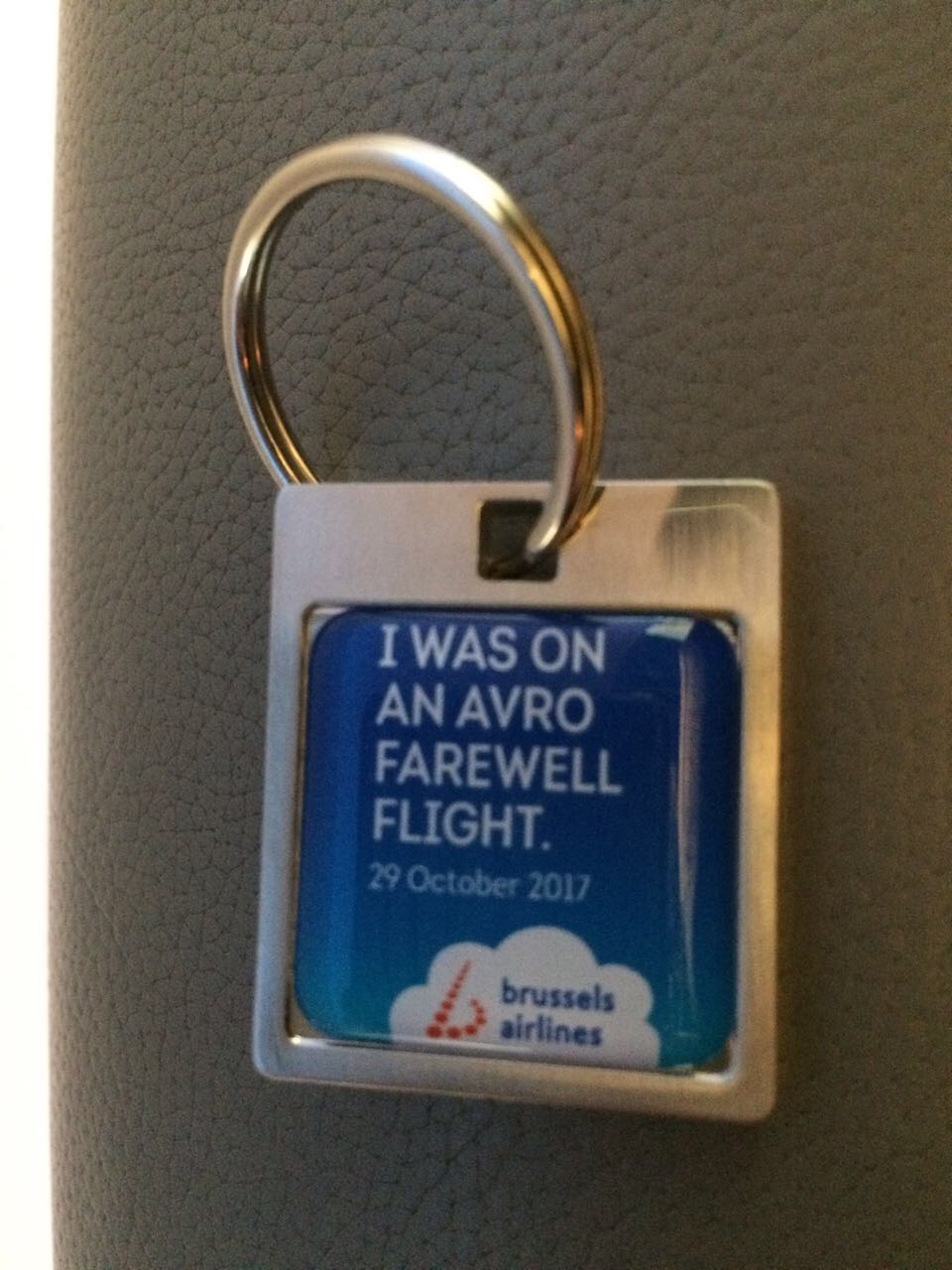 a keychain with a blue square with white text