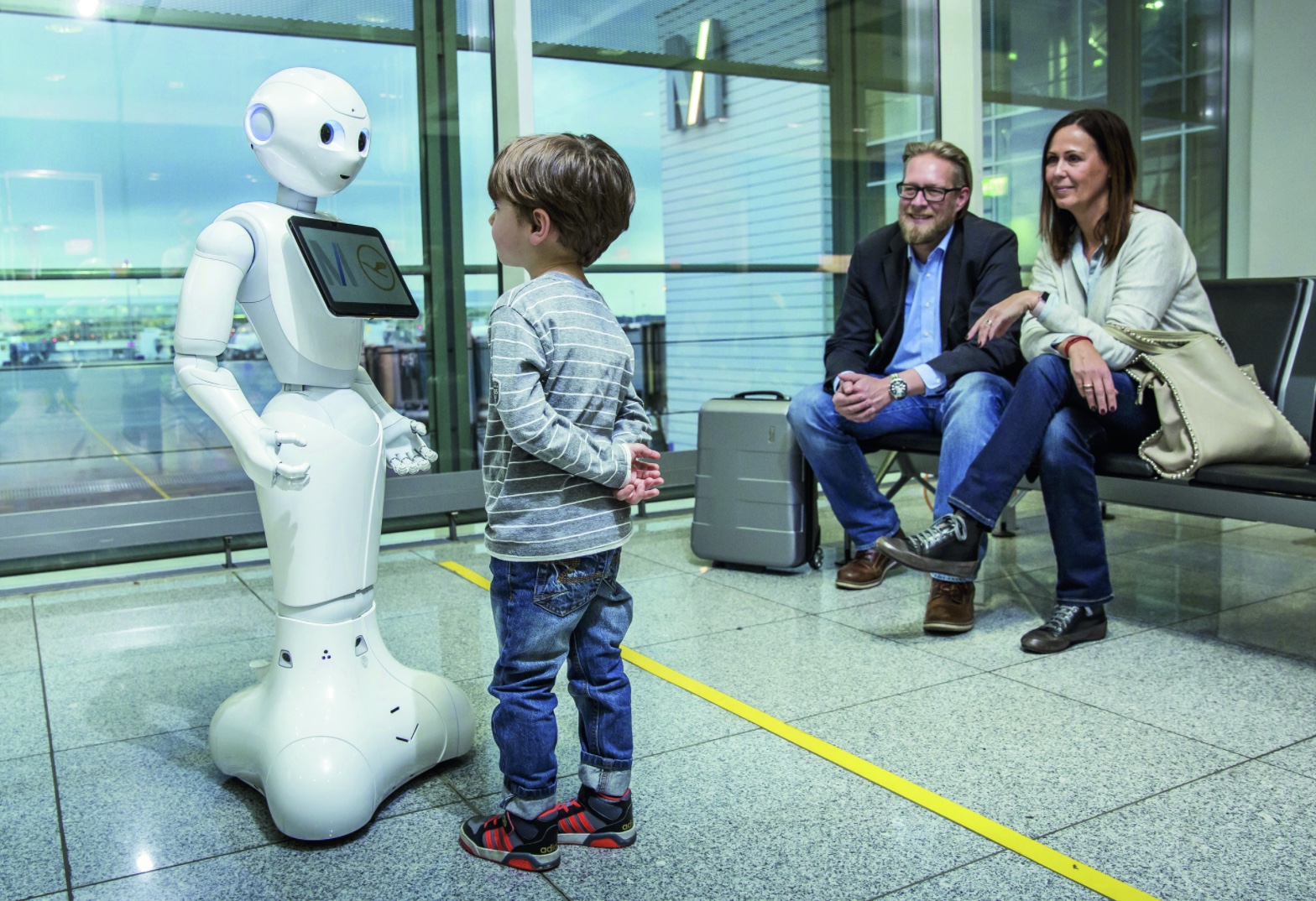 a child standing next to a robot