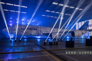 a large building with lights and a plane