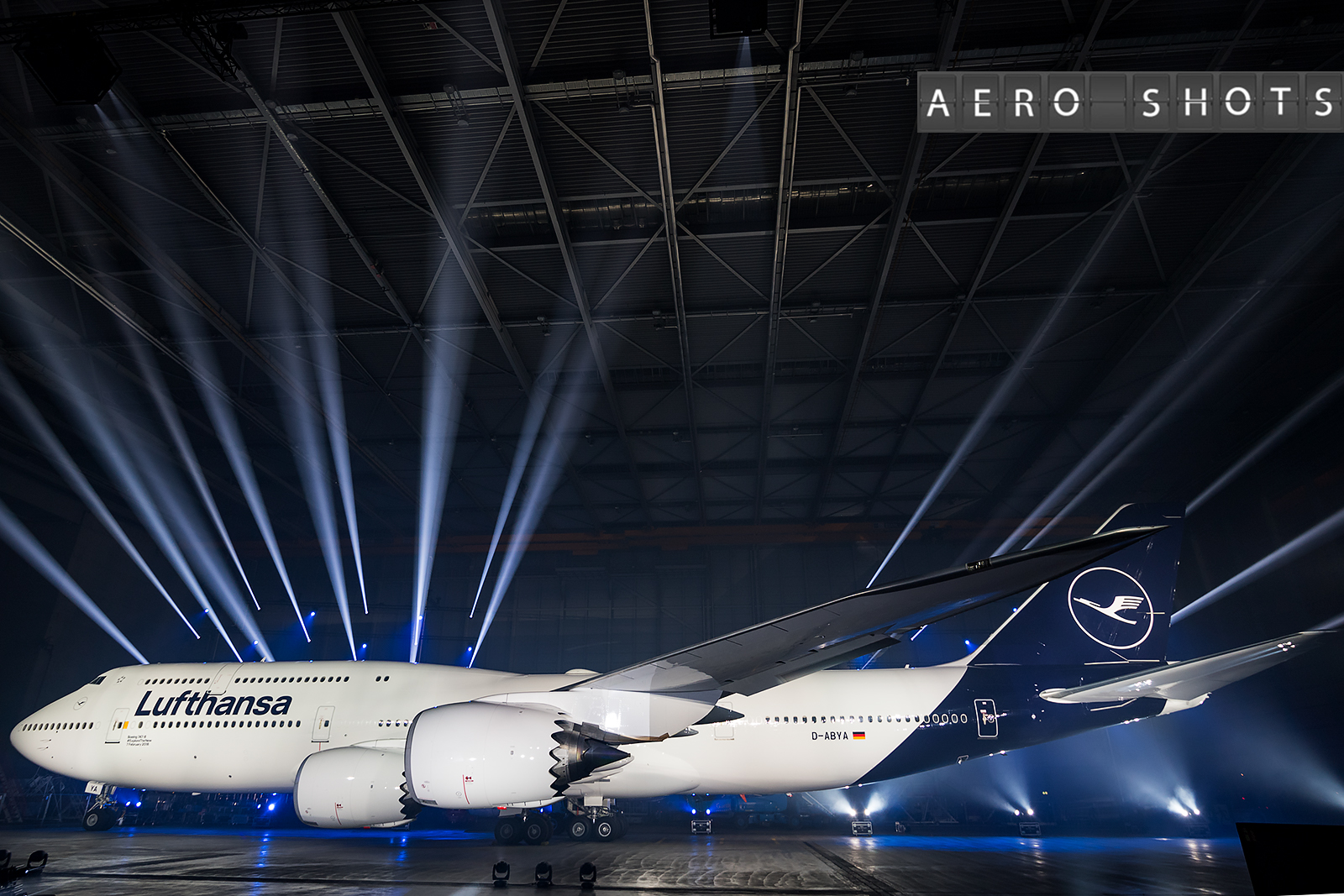 a large airplane in a hangar with bright lights
