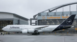 a large white airplane parked in front of a building